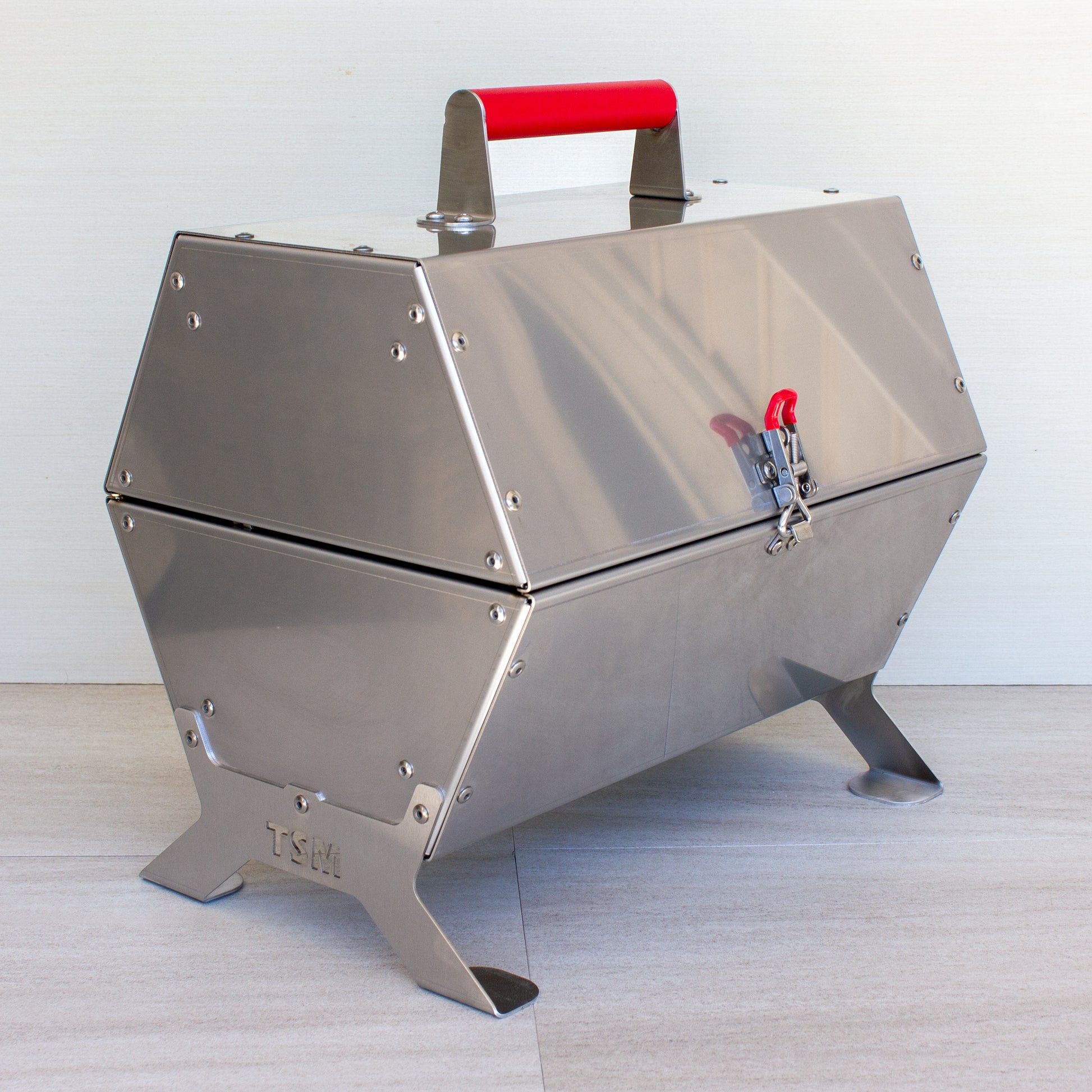 tsm-heavy-duty-portable-tool-box-grill;TSM-Toolbox-Charcoal-Grill-Infographic;side_view_of_the_portable_TSM_tool_box_grill;closed_position_of_the_tool_box_grill;21-lb-heavy-duty-portable-grill-to-last-a-lifetime;cooking_sausages_on_grill;some_vegetables_and_chicken_wings_on_TSM_tool_box_grill